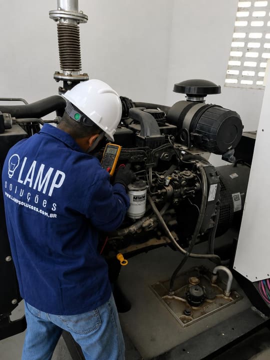 Técnico da LAMP medindo parâmetros elétricos de um grupo gerador com multímetro