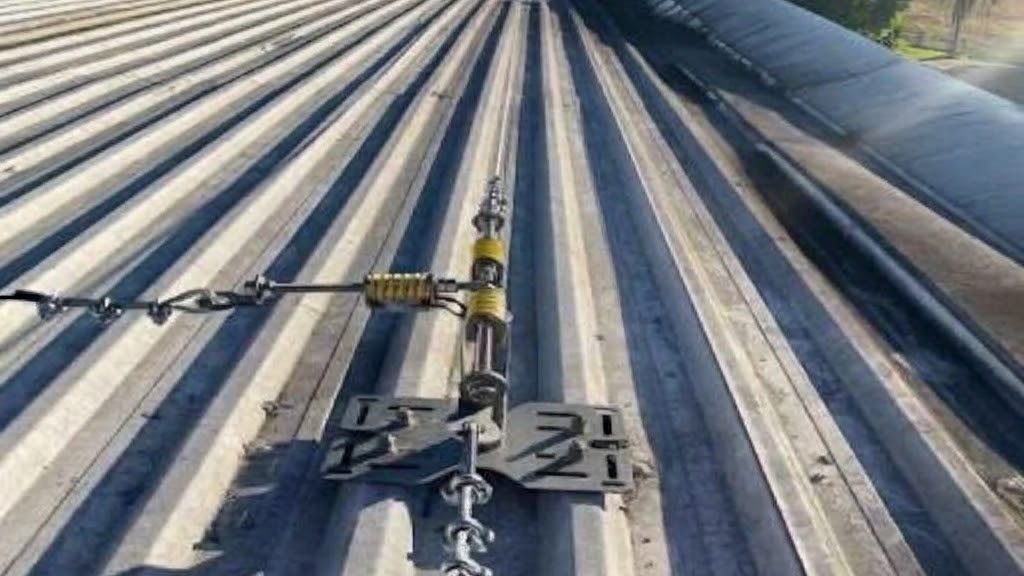 Linha de vida flexível em telhado metálico: cabo de aço e dispositivo de ancoragem fixado à cobertura